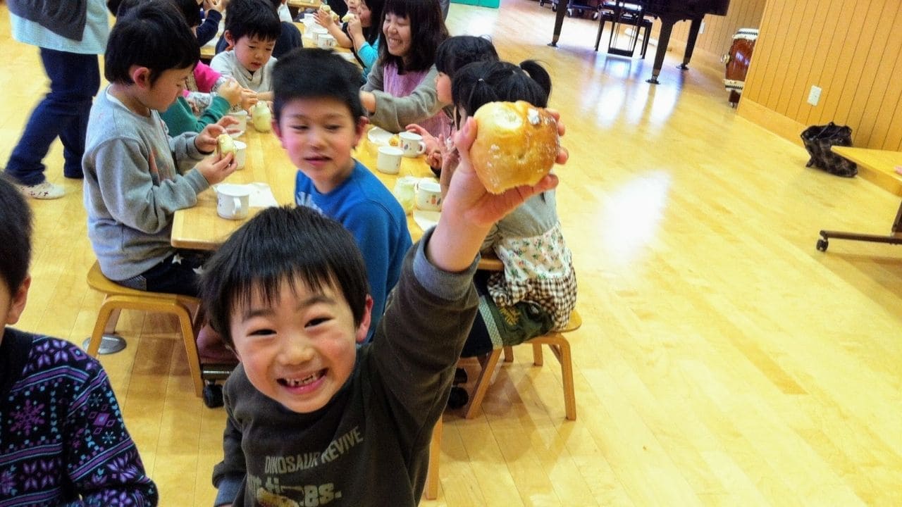 パンを頬張って笑っている子どもの様子 | アレルギー対応パンのtonton