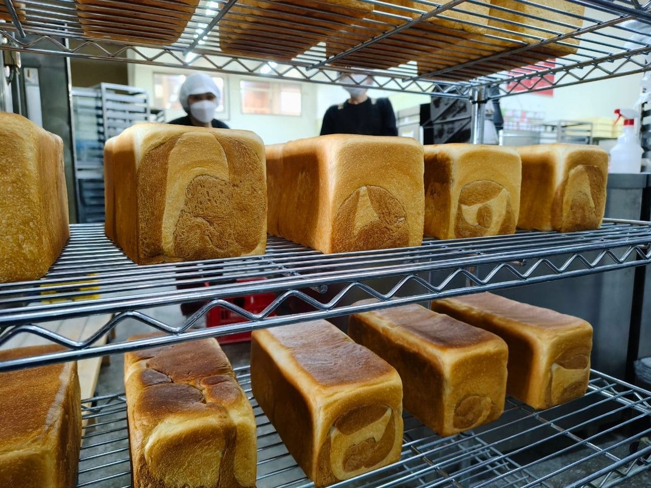 焼き上がった角食パンが棚に並んでいる。側面にマーブル模様が見える | アレルギー対応パンのtonton
