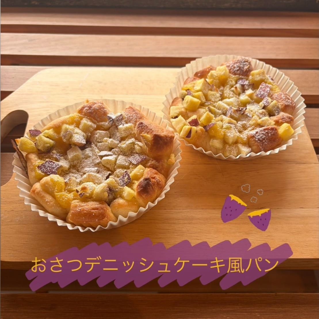 紙カップに入った「おさつデニッシュケーキ風パン」2個。デニッシュ生地にカスタードクリーム、角切りのさつまいもがたっぷりのり、粉糖がふんわりかかっている | アレルギー対応パンのtonton